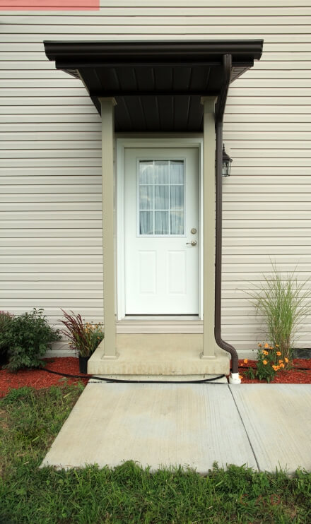 Separate basement entrance with white door and awning